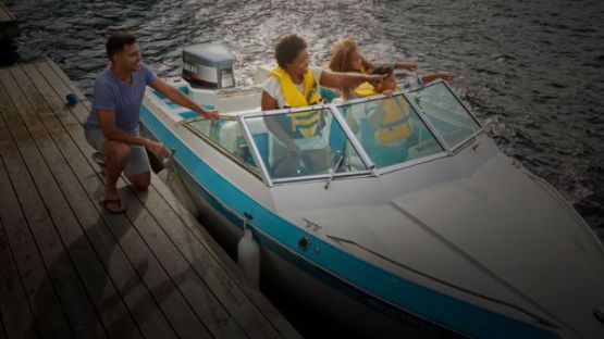 Family of three on a small pleasure craft near a dock