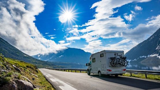 RV Motorhome on a highway surrounded by mountains